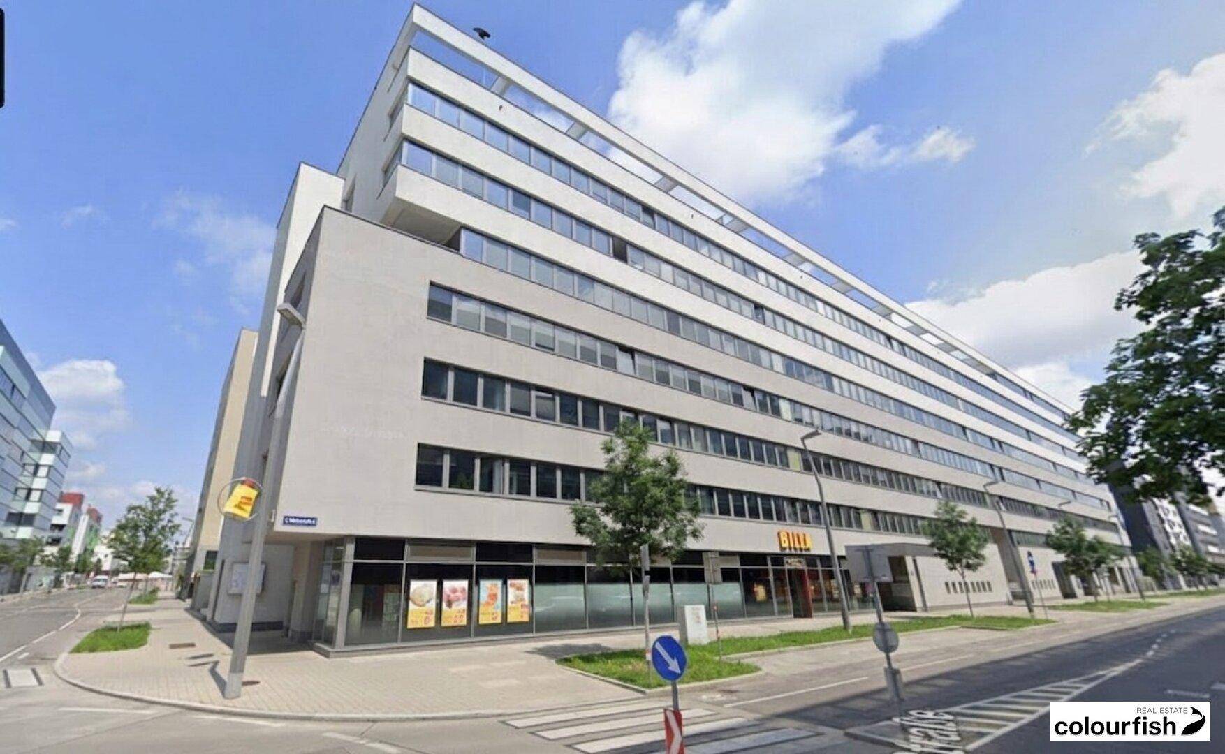 Modernes Geschäftsgebäude mit einer Billa-Filiale im Erdgeschoss und zahlreichen Bürofenstern darüber.