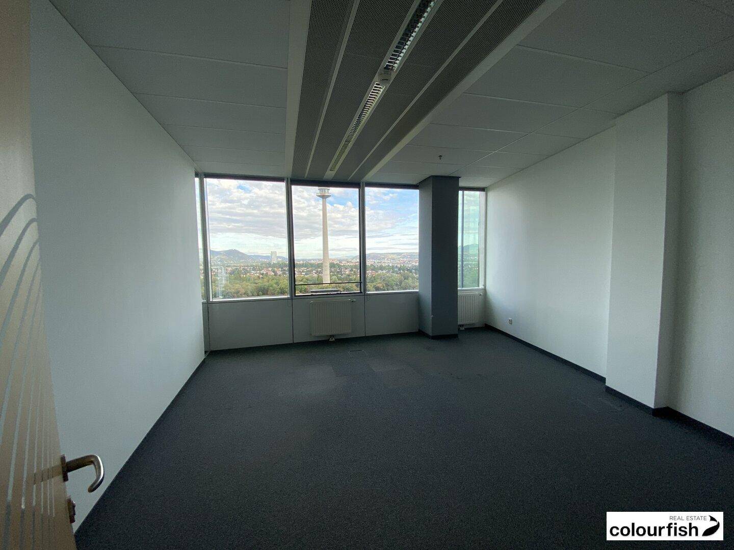 Helles Büro mit Teppichboden und Panoramablick auf die Stadt und den Fernsehturm.
