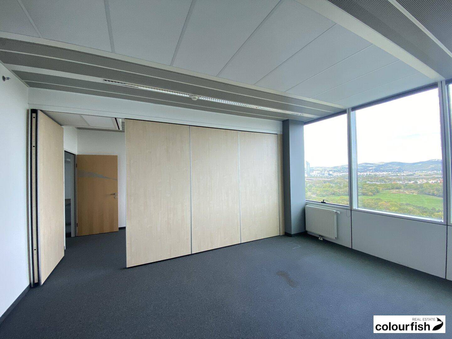 Flexibles Büro mit verschiebbaren Trennwänden und großen Fenstern für viel Tageslicht.