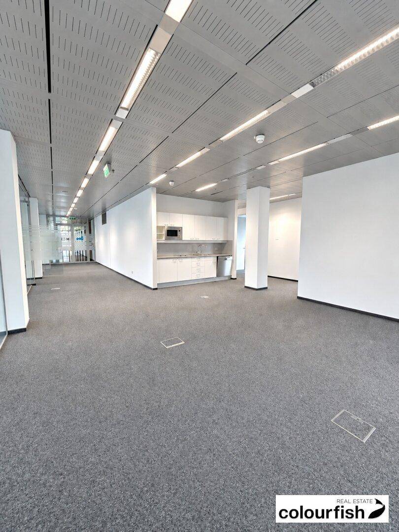 Leerer Bürobereich mit einer schlichten Teeküche und viel Platz für individuelle Gestaltung.