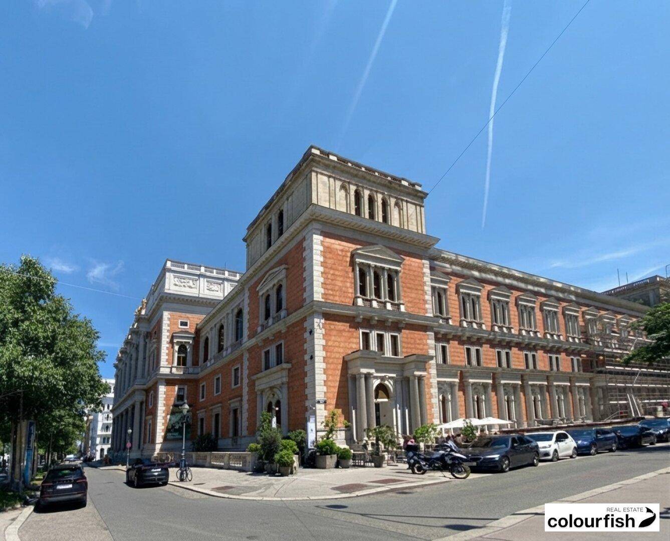 Historisches Gebäude mit beeindruckender Architektur und detailreicher Fassade unter blauem Himmel.