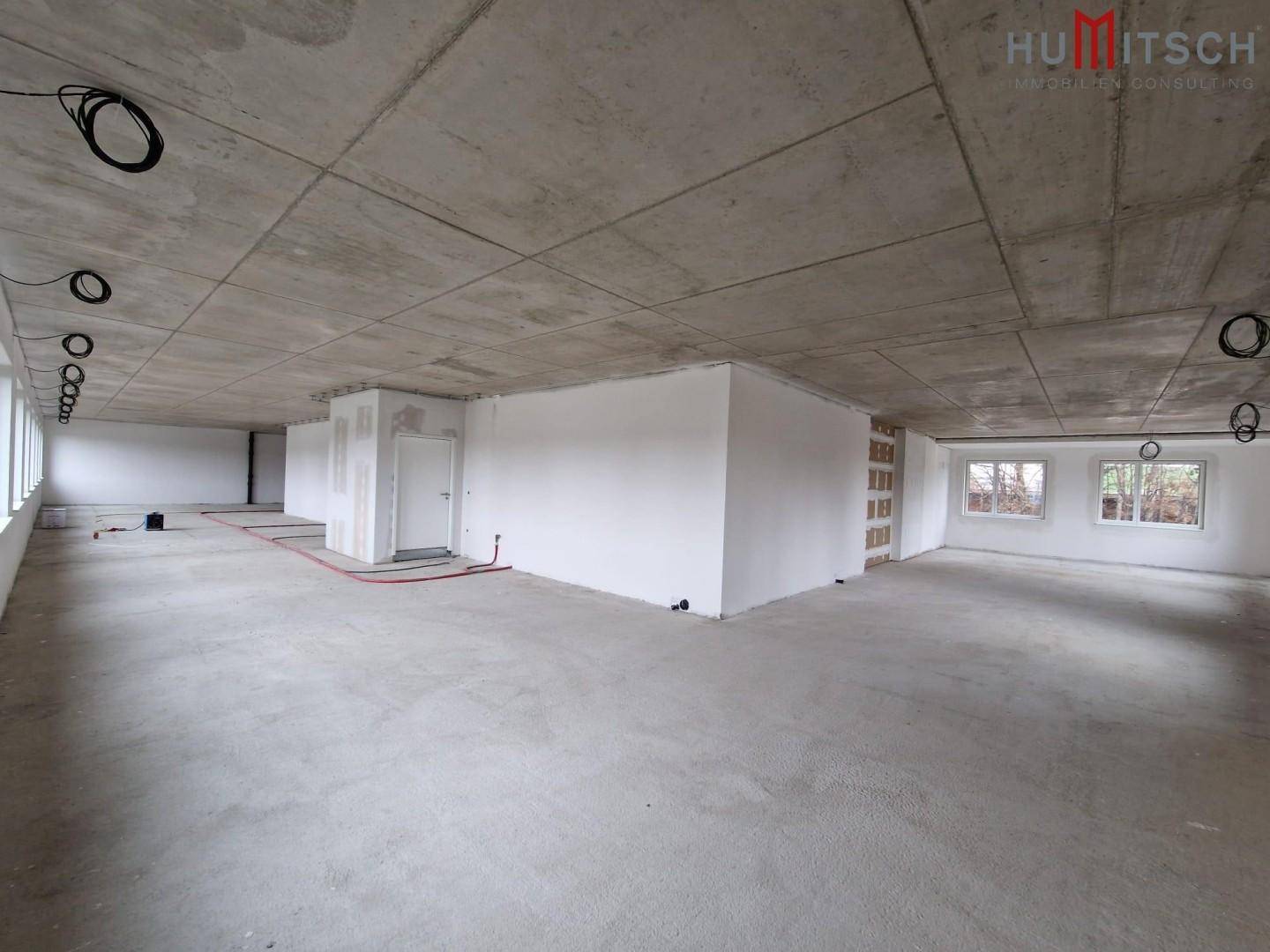 Rohbau eines Büroraums mit Betonboden und teilweise errichteten Trennwänden.