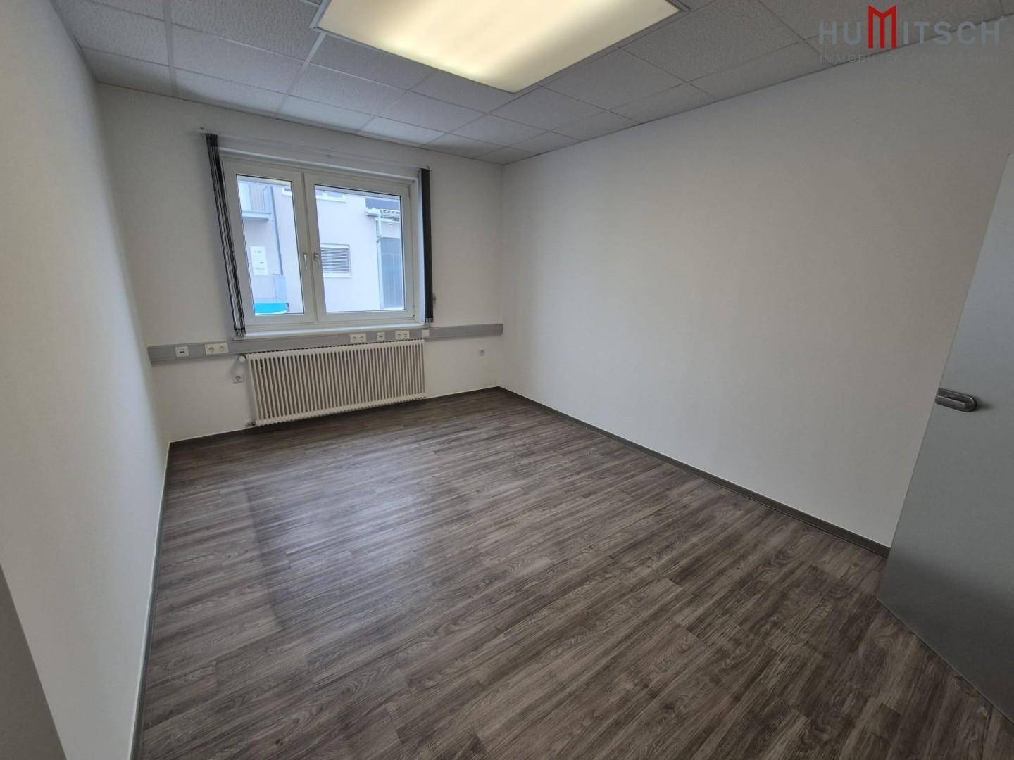 Helles Einzelbüro mit Laminatboden und einem Fenster, ideal für konzentriertes Arbeiten.