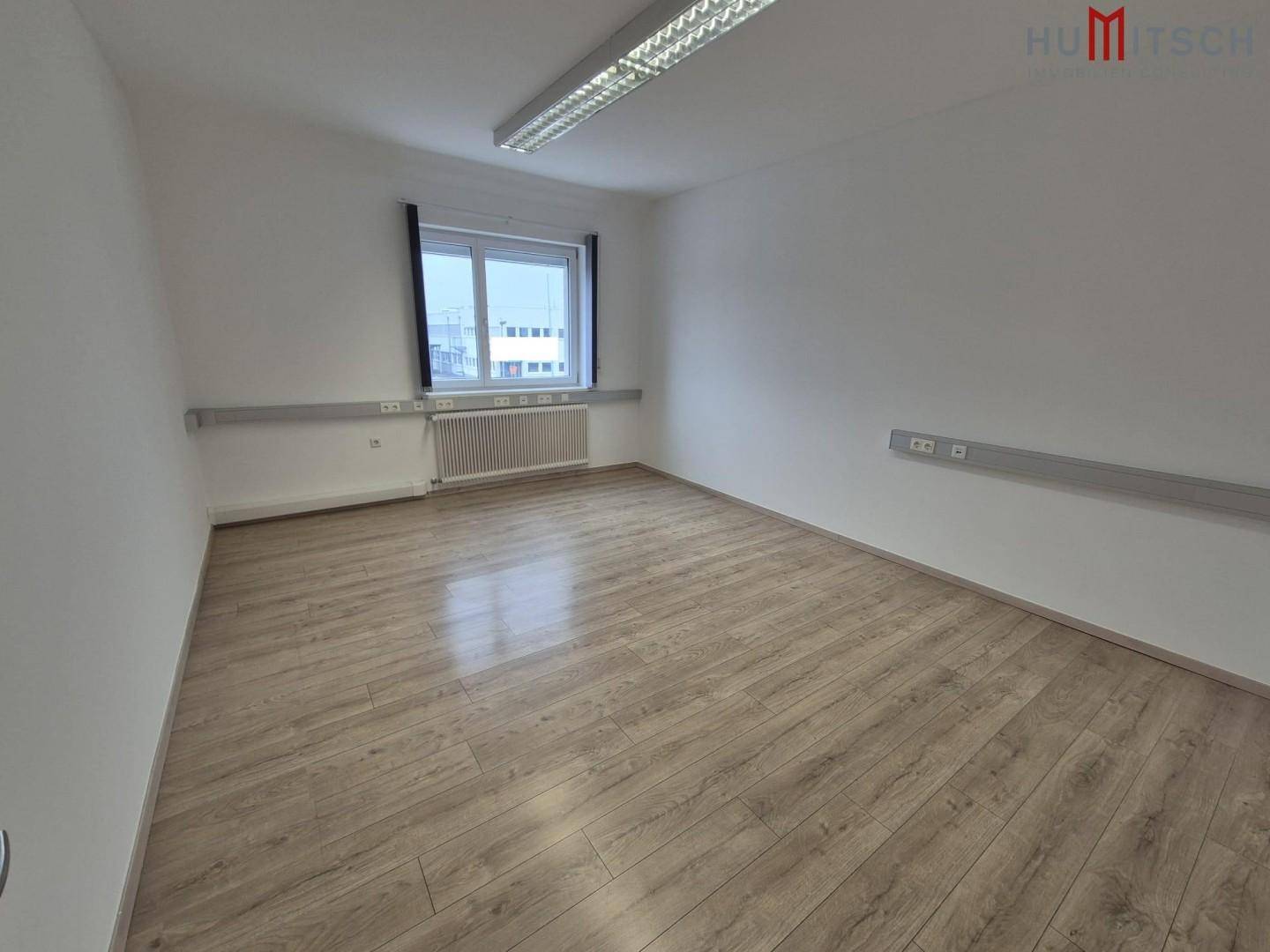 Modernes Büro mit Laminatboden und einem Fenster, bietet eine angenehme Arbeitsatmosphäre.