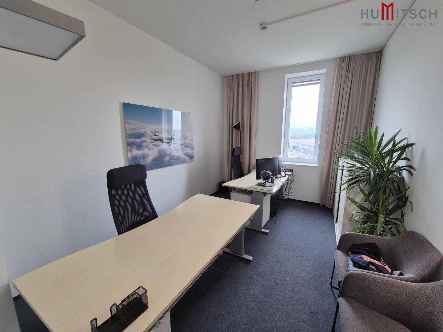 Einzelbüro mit Schreibtisch, Bürostuhl und einem Bild an der Wand.