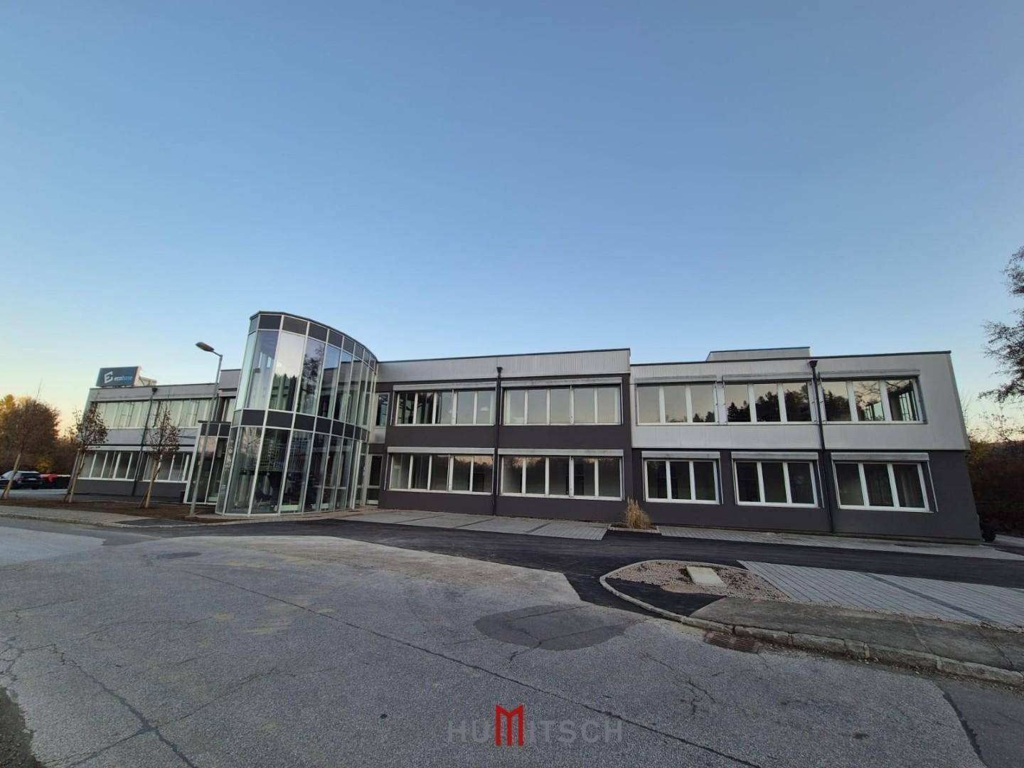 Gesamtansicht des modernen Bürogebäudes mit Parkplätzen und einer ansprechenden Architektur.