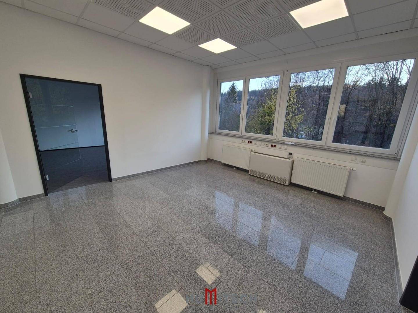 Helles Büro mit Granitboden und großen Fenstern, die viel Tageslicht und einen weiten Ausblick bieten.