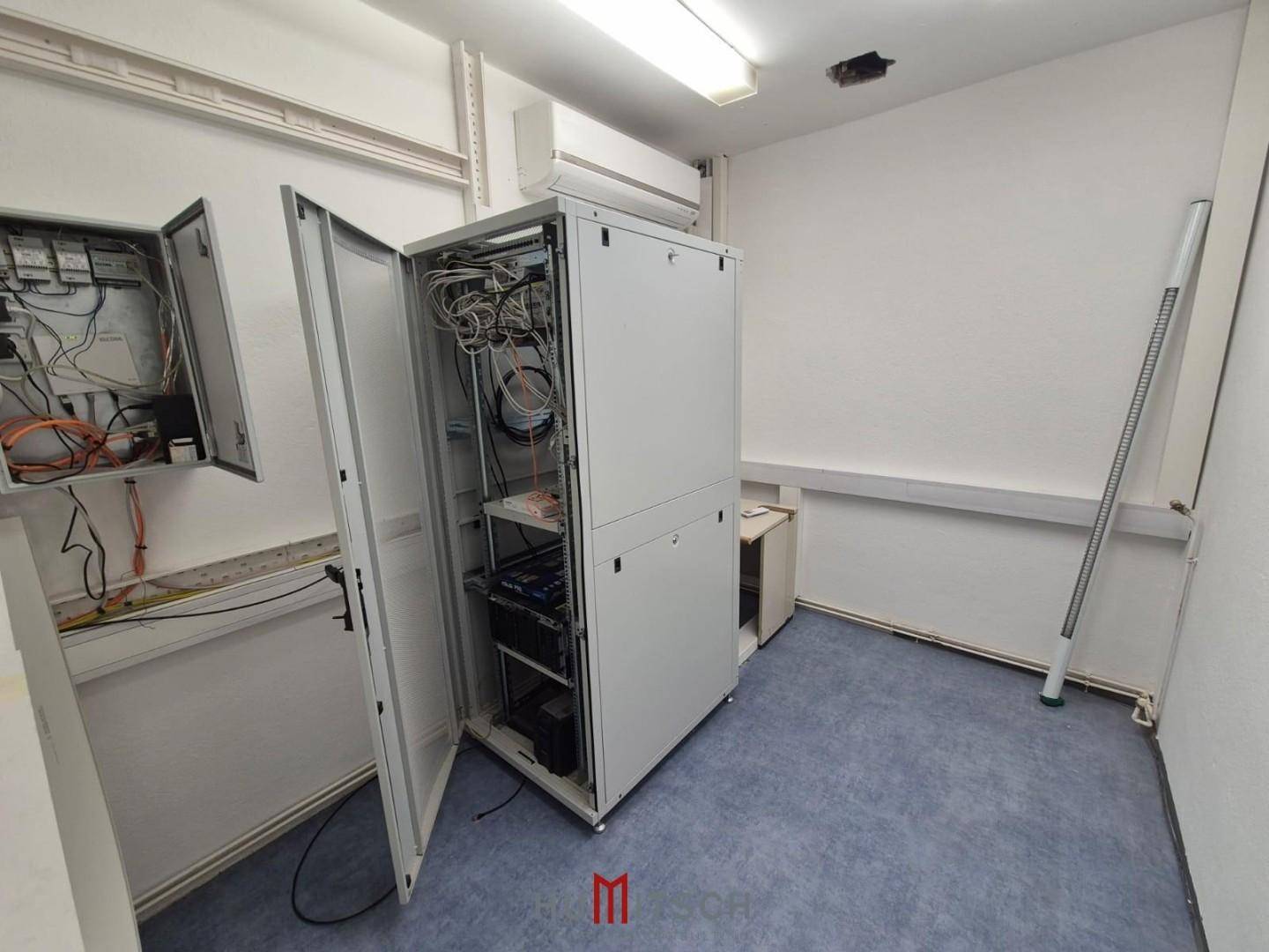 Serverraum mit einem Serverschrank, Klimaanlage und Verkabelung für die IT-Infrastruktur.