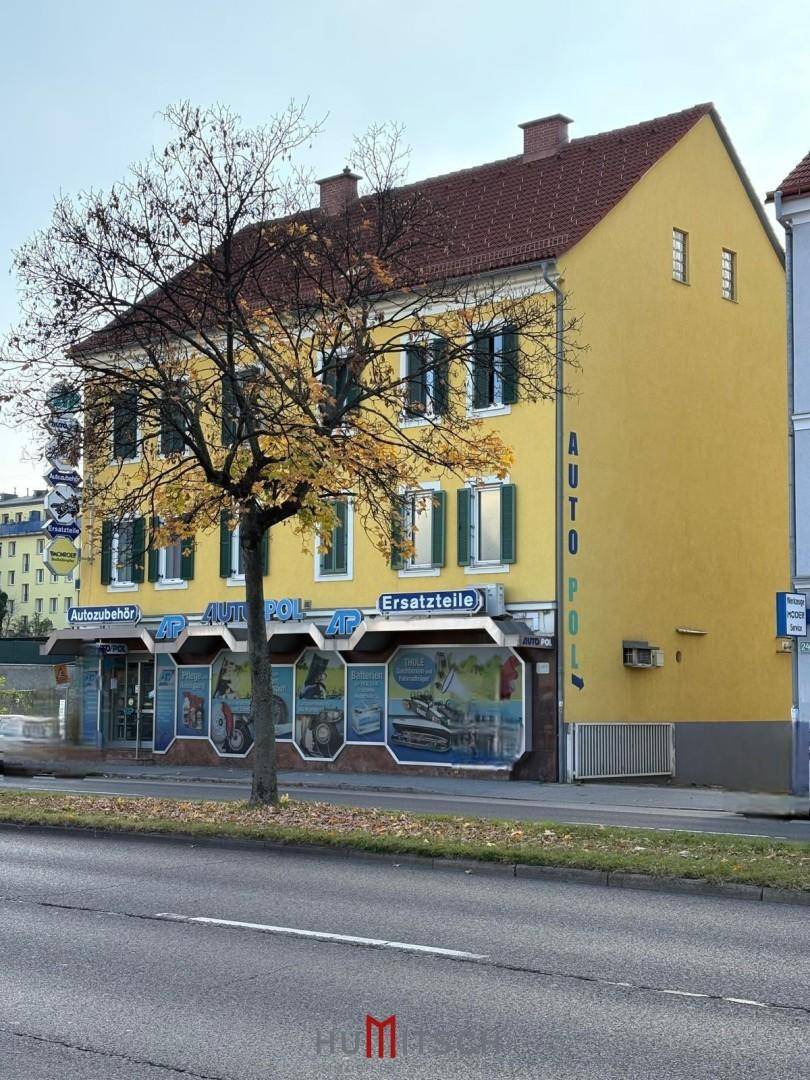 Schräge Ansicht des gelben Gebäudes mit traditionellem Dach und Geschäftsfassade.