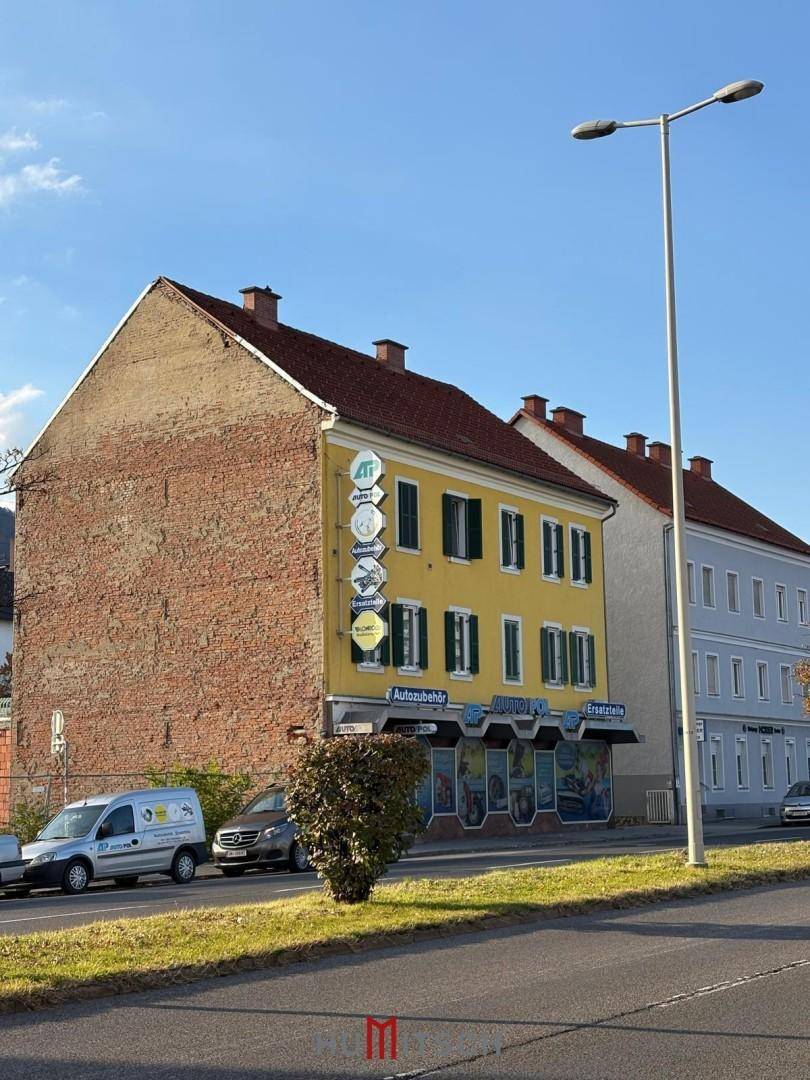 Seitenansicht des Gebäudes mit freiliegender Ziegelwand und traditionellem Dach.