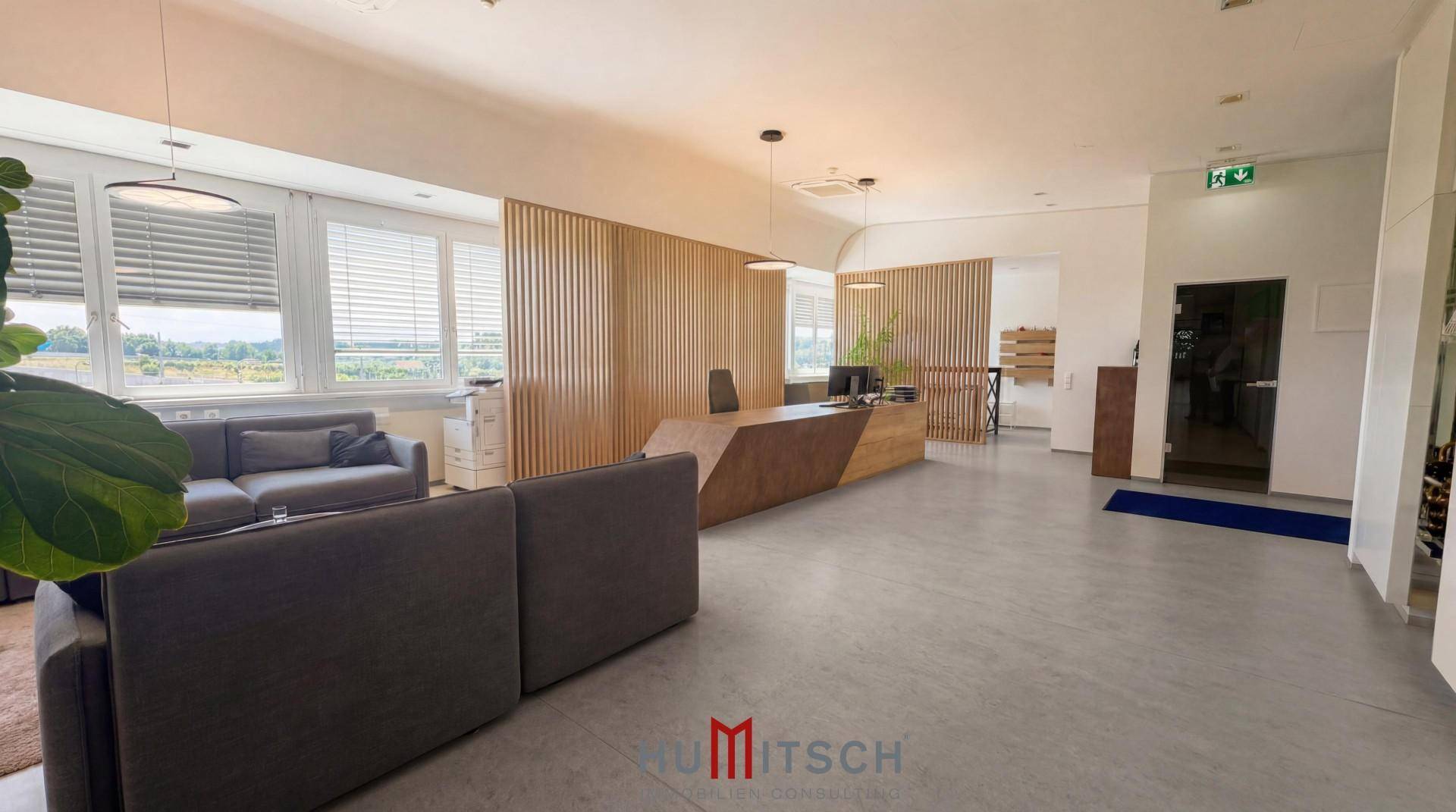 Moderner Empfangsbereich mit stilvoller Rezeptionstheke, bequemen Sofas und großen Fenstern.