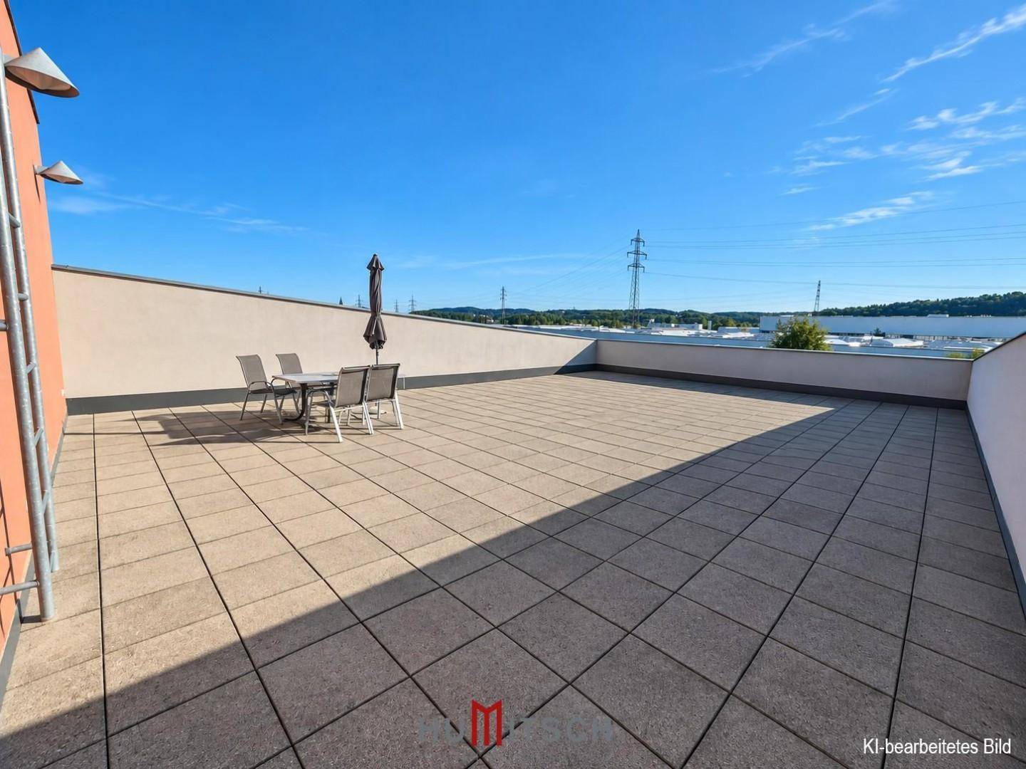 Geräumige Dachterrasse mit Fliesenboden und Sitzgelegenheiten unter blauem Himmel.