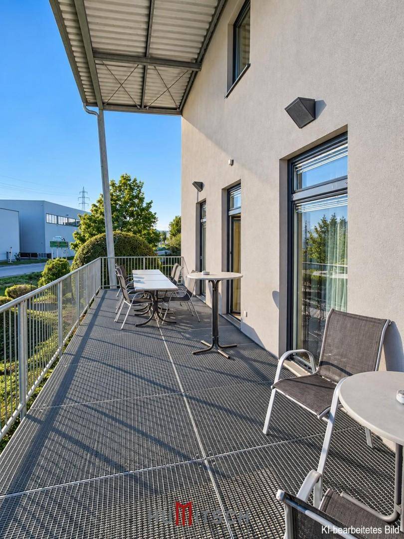 Großer Balkon mit Metallboden und Sitzgelegenheiten, bietet einen Blick auf die Umgebung.