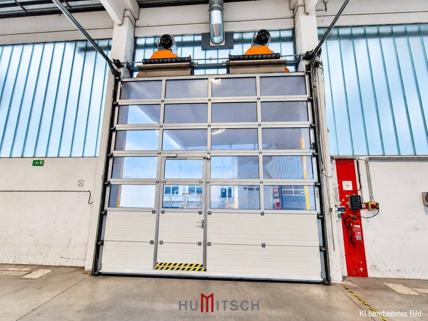 Großes Sektionaltor mit vielen Fenstern und einer integrierten Tür in einer Industriehalle.