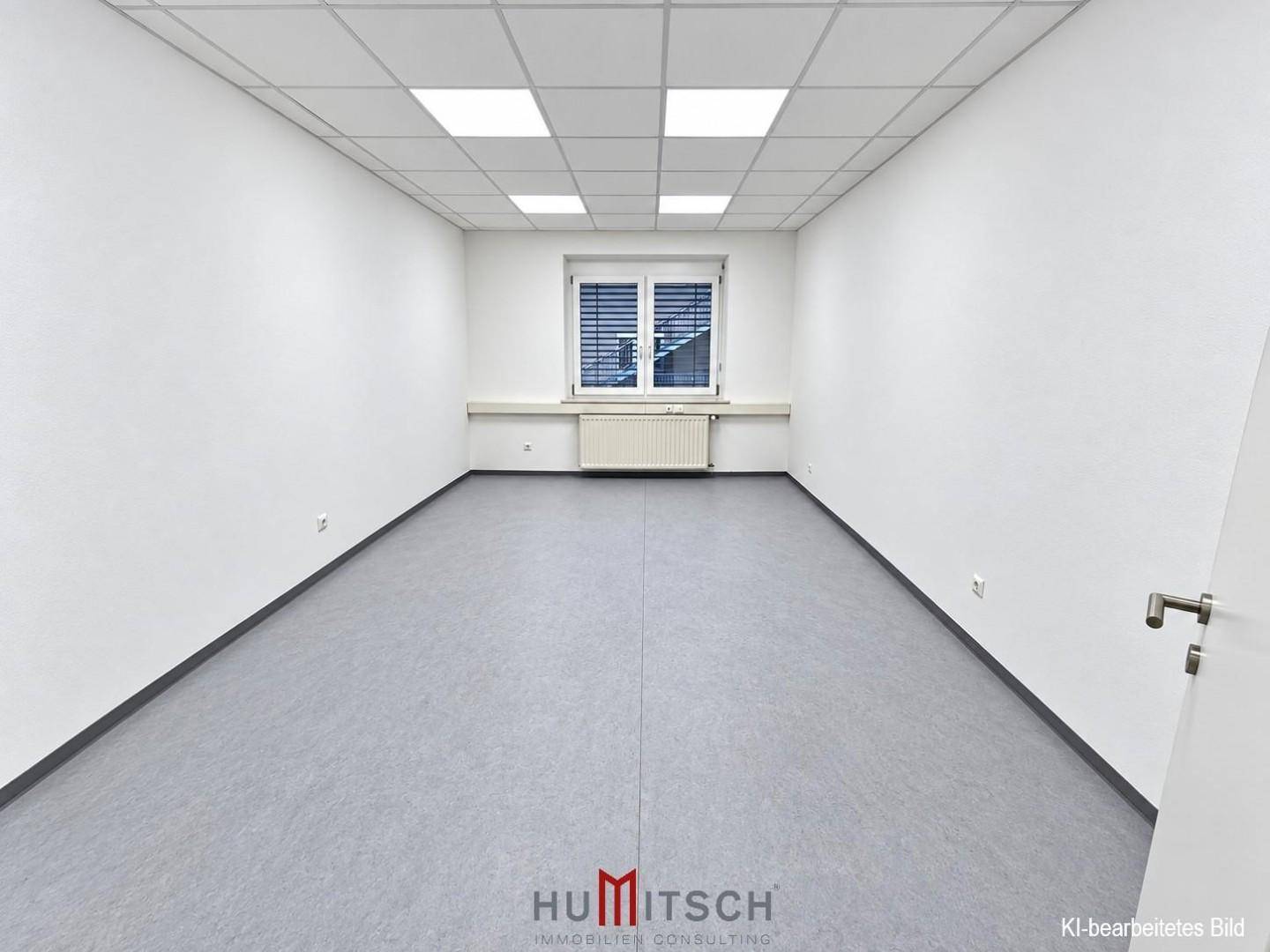 Leerer Büroraum mit einem Fenster, Heizkörper und modernen Deckenpaneelen, bereit zur individuellen Gestaltung.