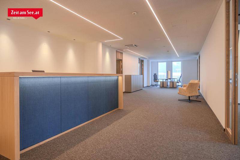 Moderner Empfangsbereich in einem Bürogebäude mit Teppichboden und indirekter Deckenbeleuchtung, der viel Platz bietet.