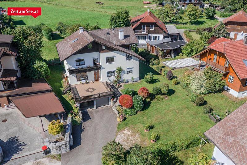 Vogelperspektive eines Einfamilienhauses mit gepflegtem Garten, Terrasse und Doppelgarage.