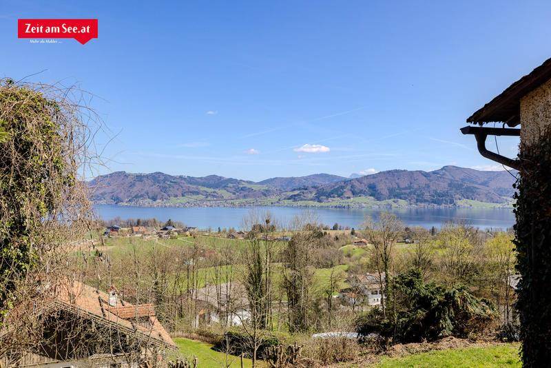 Weitläufiger Blick über den See und die sanften Hügel der Landschaft an einem sonnigen Frühlingstag.