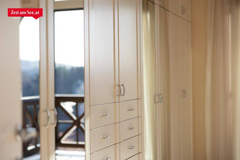 Heller Einbauschrank mit Schubladen und Blick auf den Außenbereich.