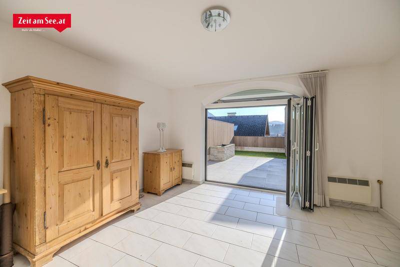 Geräumiges Zimmer mit traditionellem Holzschrank und Zugang zu einer privaten Terrasse.