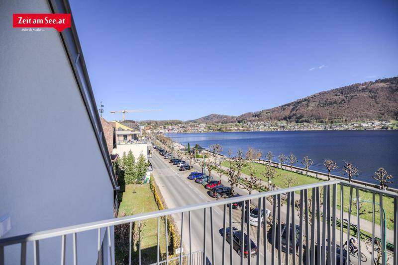 Balkon mit weitem Blick über die Uferpromenade, den See und die umliegende Stadtlandschaft.