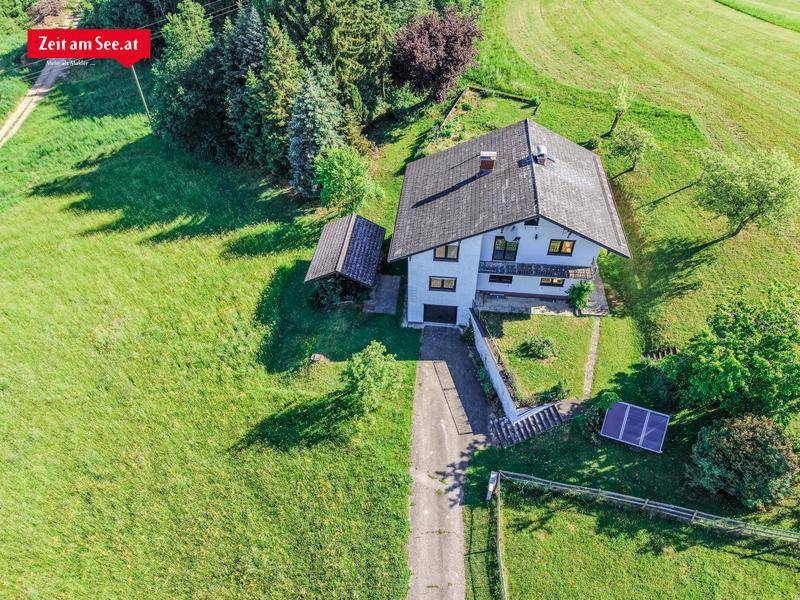 Luftaufnahme des Hauses mit Zufahrt, Garten und Photovoltaikanlage auf dem Grundstück.