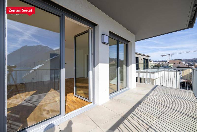 Geräumige Terrasse mit Fliesenboden und weitem Blick auf die Umgebung und die Berge.