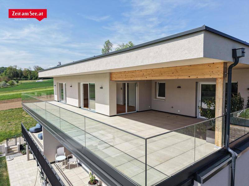 Große Terrasse mit Glasgeländer und weitem Blick über die umliegende Landschaft und Felder.