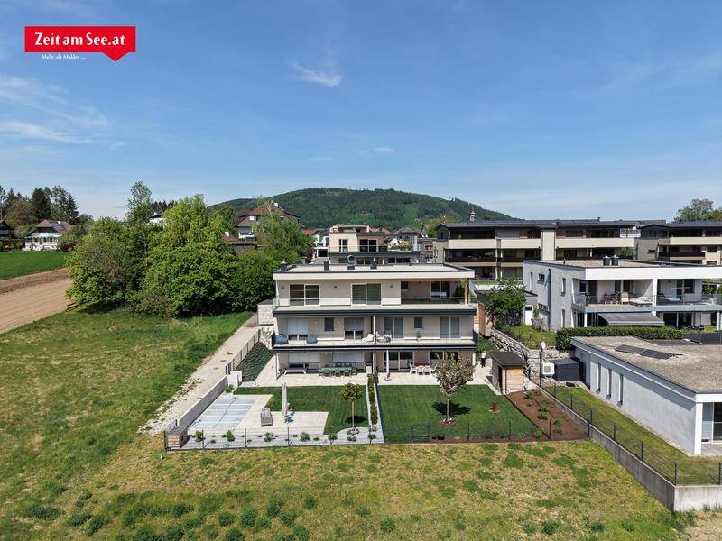 Luftaufnahme eines modernen Apartmentgebäudes mit gepflegten Grünflächen und ländlicher Umgebung.