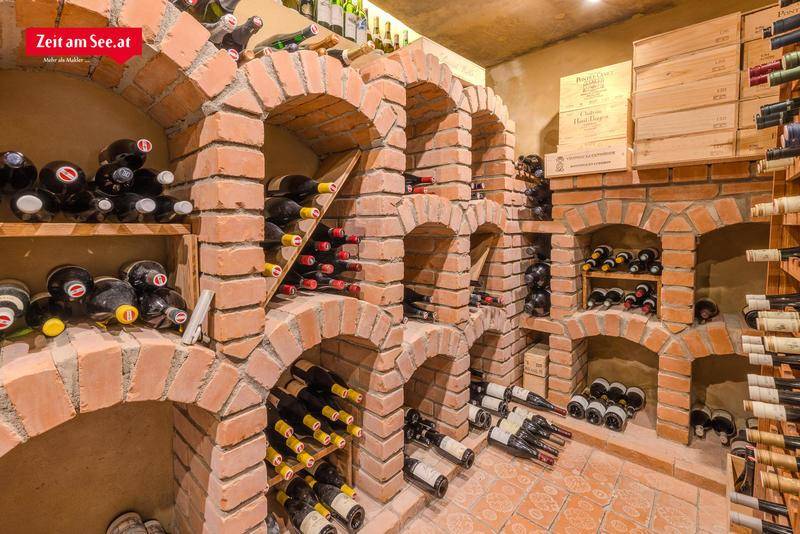 Rustikaler Weinkeller mit Ziegelgewölben und zahlreichen Weinregalen, perfekt für die Lagerung edler Tropfen.