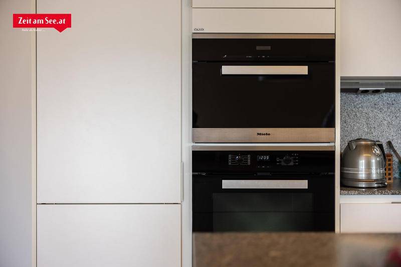 Hochwertige Einbaugeräte in der modernen Küche, darunter ein Backofen und eine Mikrowelle von Miele.