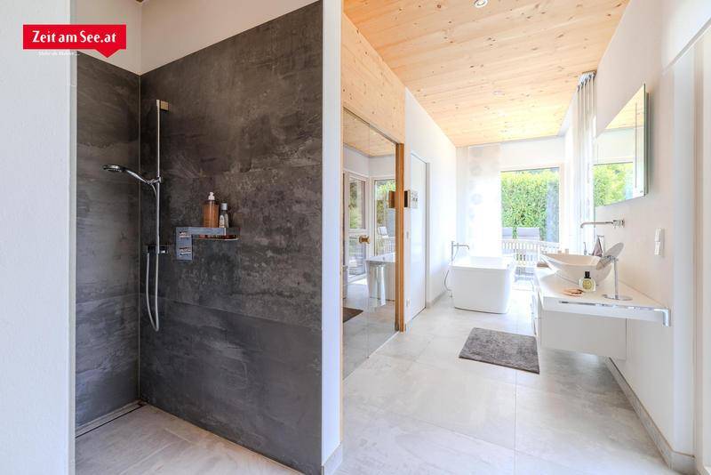 Modernes Badezimmer mit begehbarer Dusche, freistehender Badewanne und Holzdecke.