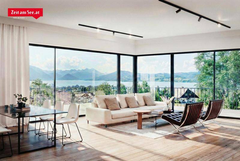 Helles Wohn-Esszimmer mit raumhohen Fenstern, die einen atemberaubenden Blick auf den See und die Berge bieten.