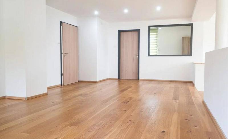 Geräumiger, heller Raum mit Holzboden und modernen Türen, bereit zur individuellen Gestaltung.