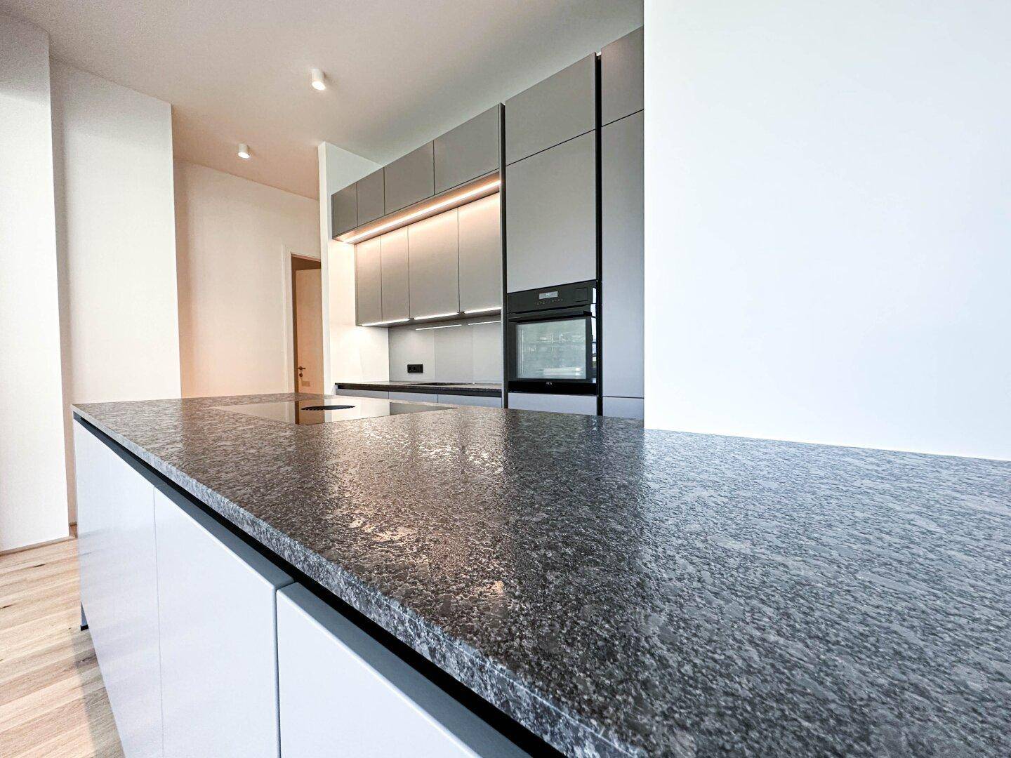 Hochwertige Küchenarbeitsplatte aus dunklem Granit mit glänzender Oberfläche.