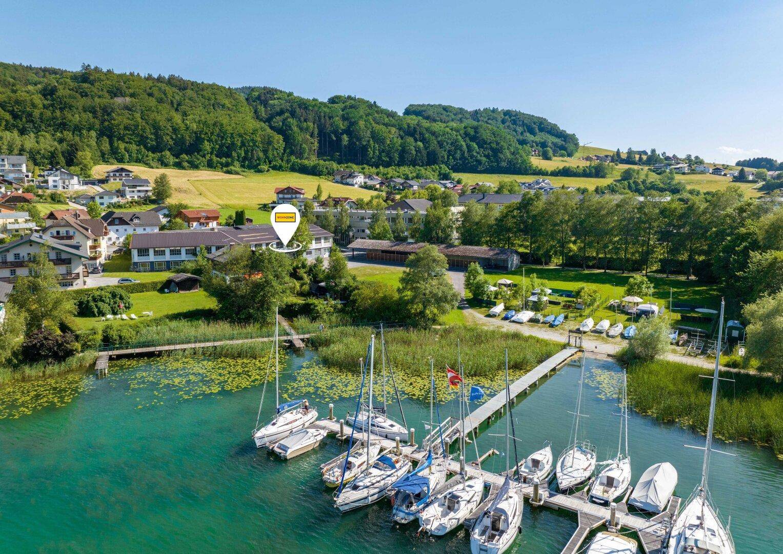 Luftaufnahme des Anwesens mit Blick auf den Mattsee, Segelboote und die grüne Landschaft.
