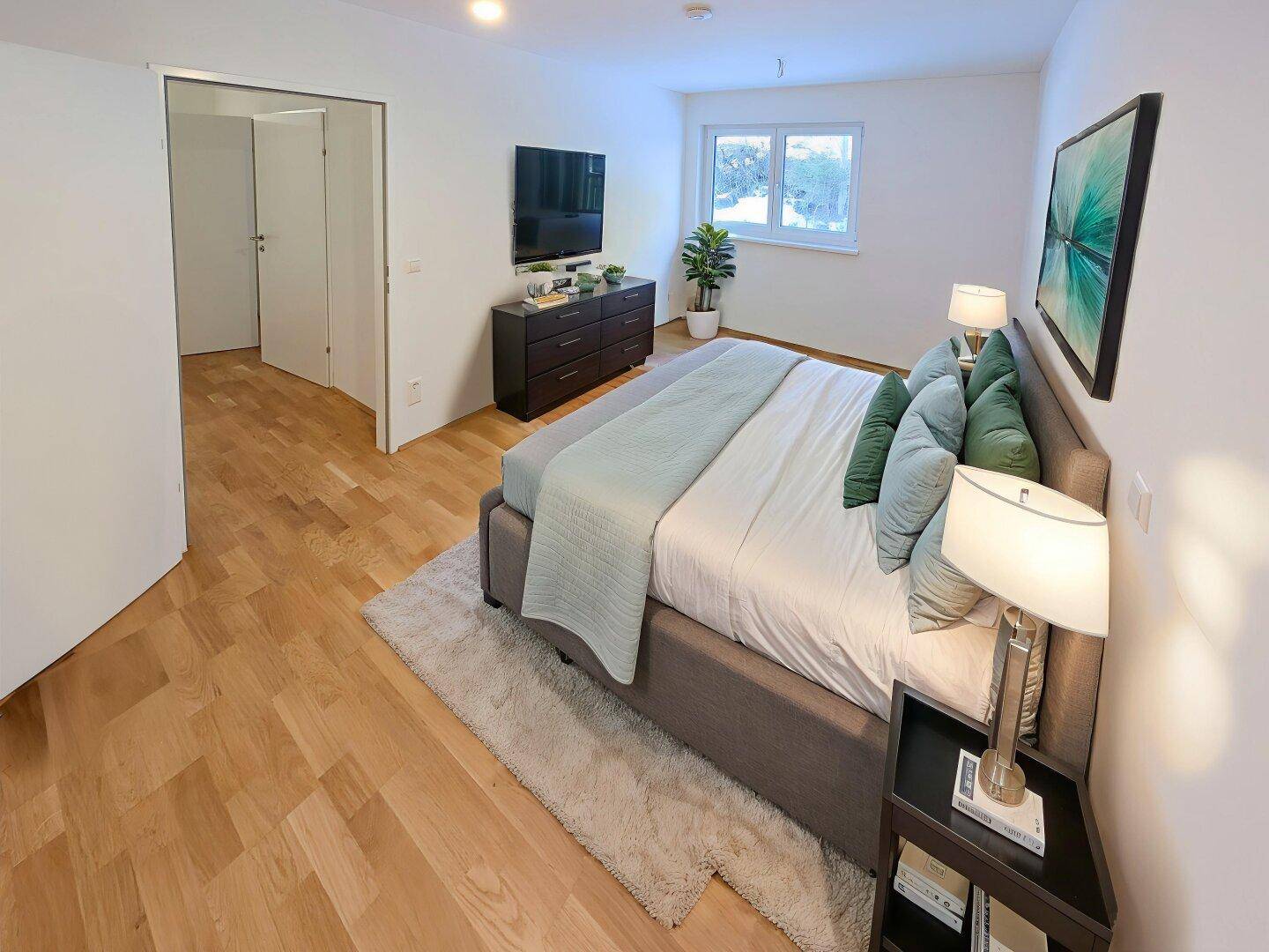 Helles Schlafzimmer mit Holzboden, großem Bett, modernen Möbeln und natürlichem Lichteinfall.