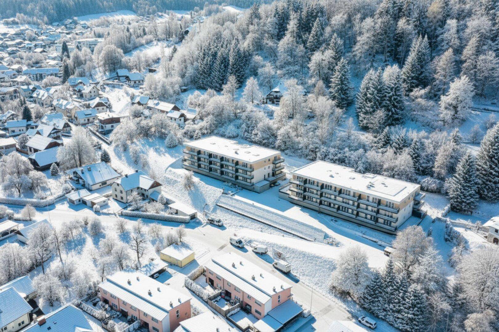 Luftaufnahme der Apartmentgebäude und der verschneiten Umgebung im Winter.
