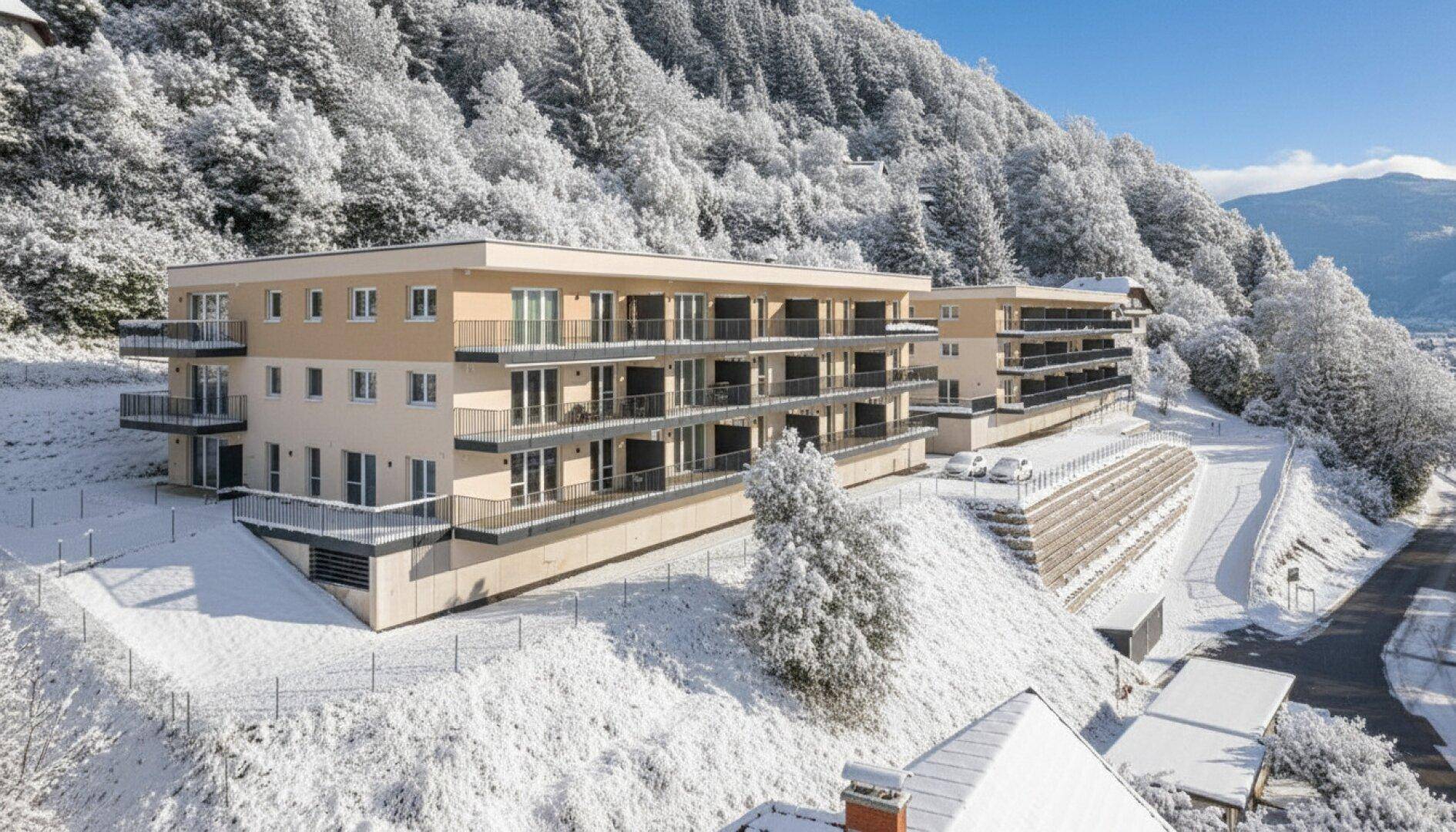Die modernen Apartmentgebäude im Winter, eingebettet in eine verschneite Berglandschaft.