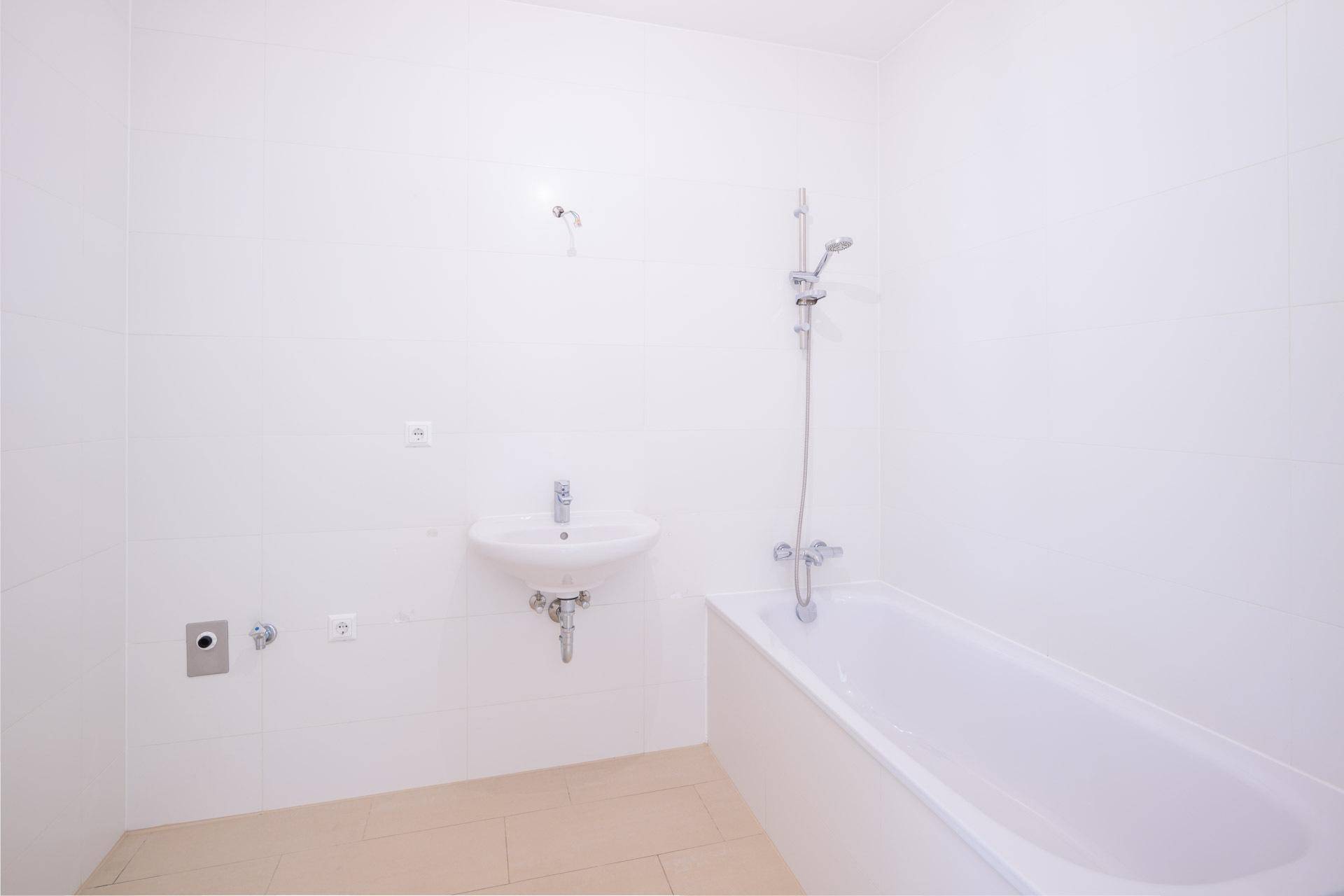 Modernes Badezimmer mit Badewanne, Waschbecken und weißen Fliesen, bereit zur Nutzung.