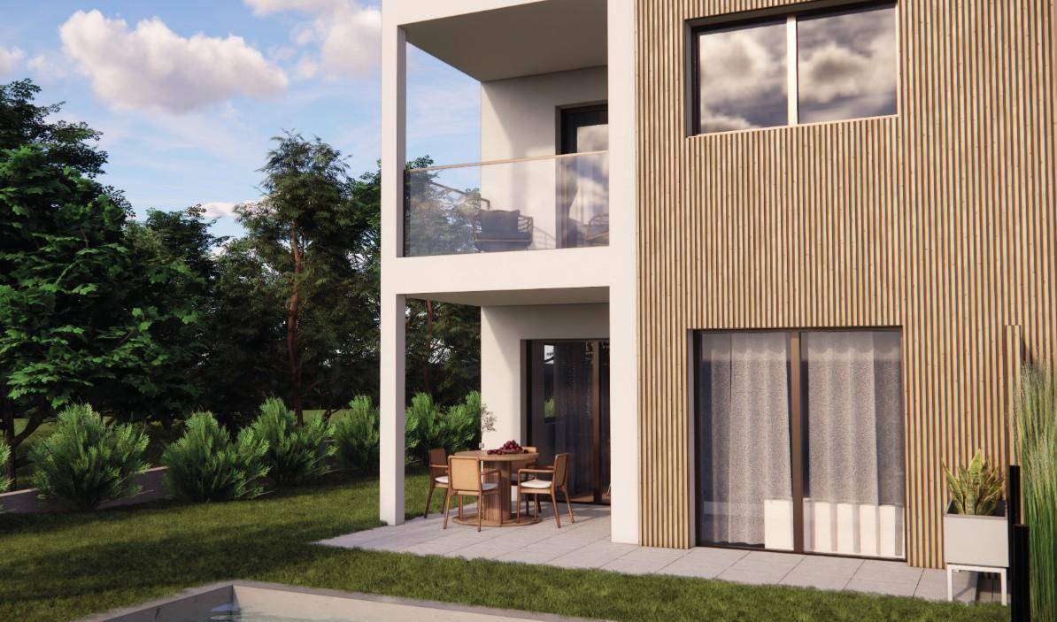 Terrasse und Balkon eines Reihenhauses mit Blick ins Grüne und modernen Gartenmöbeln.
