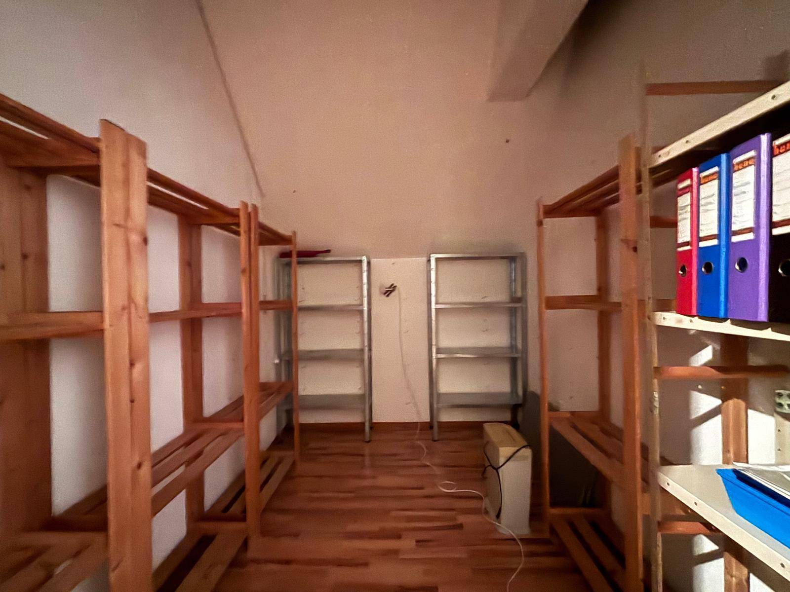 Lagerraum im Dachgeschoss mit Holzregalen und Holzboden, ideal für zusätzlichen Stauraum.