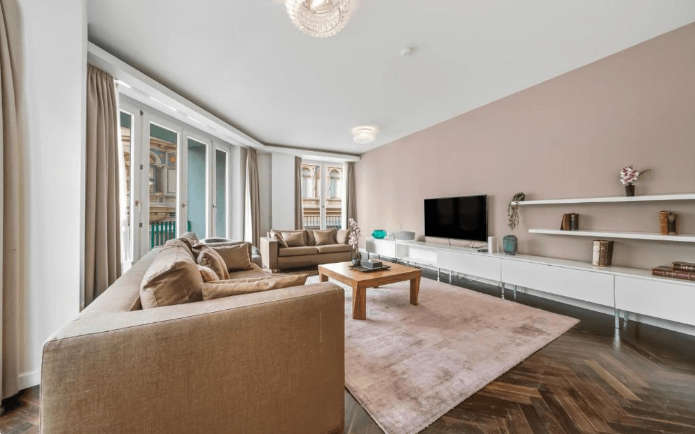 Helles Wohnzimmer mit modernem Interieur, bequemen Sofas, TV-Möbeln und Blick auf die Stadt.