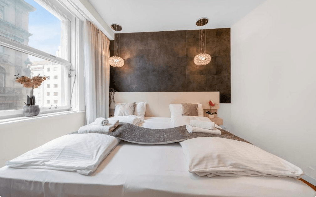 Komfortables Schlafzimmer mit großem Bett, stilvoller Wandgestaltung und weitem Blick auf die Stadt.