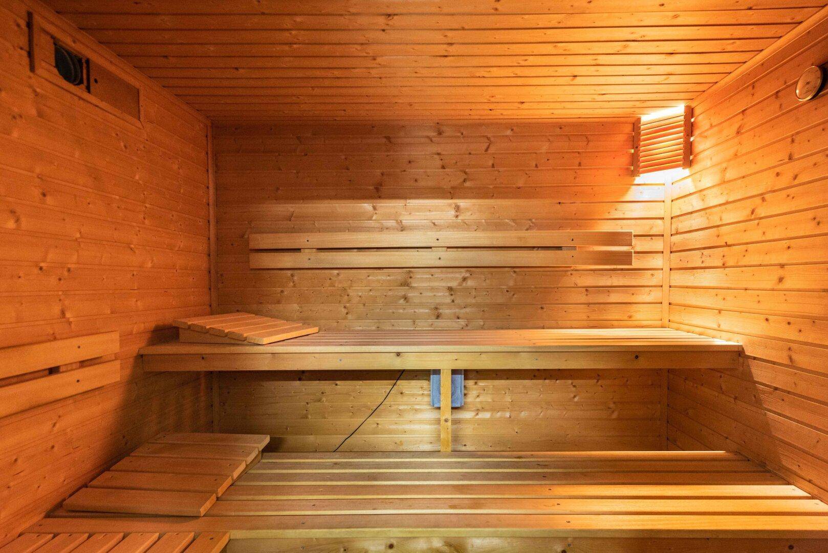 Gemütliche Holzsauna mit Bänken, die zum Entspannen und Wohlfühlen einlädt.
