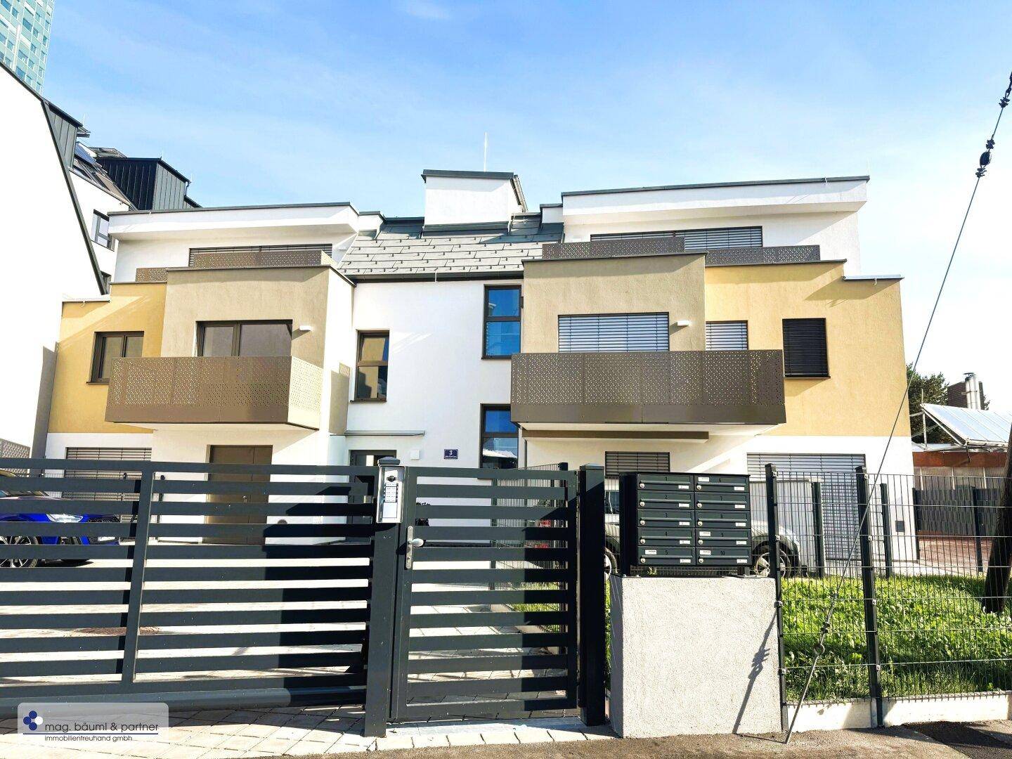Moderne Wohnanlage mit ansprechender Fassade, Balkonen und einem sicheren Eingangsbereich.
