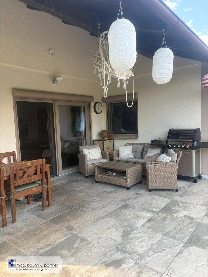 Geräumige Terrasse mit Outdoor-Möbeln, Grillbereich und Überdachung für entspannte Stunden.