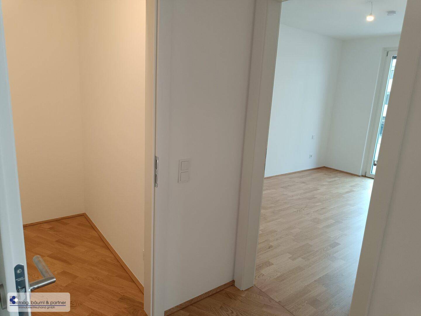 Flur mit Zugang zu einem Abstellraum und weiteren hellen Wohnräumen.