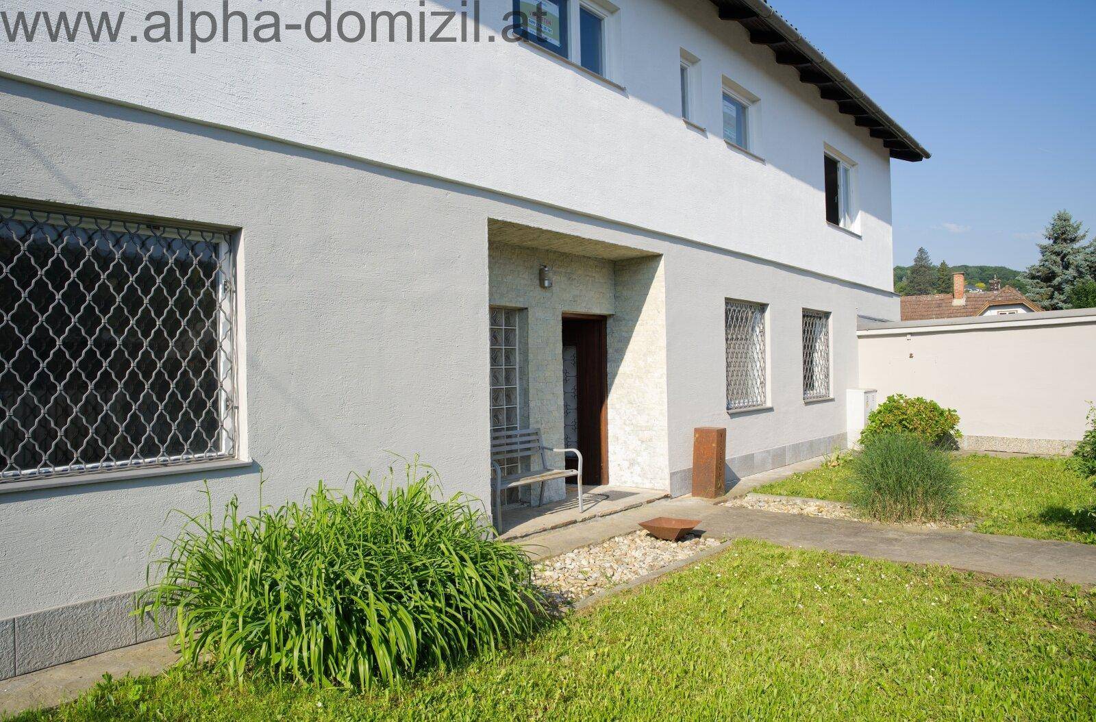 Eingangsbereich des Hauses mit kleiner Veranda und gepflegtem Vorgarten.