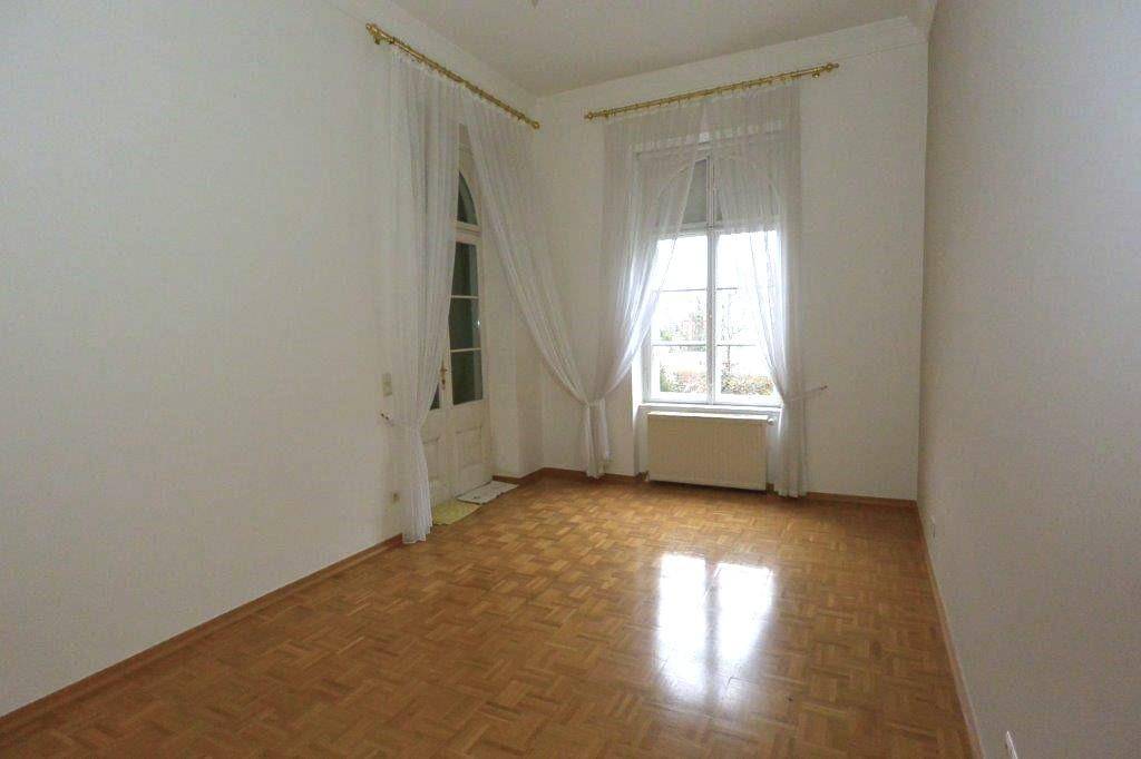 Gemütliches Schlafzimmer mit Parkettboden und Zugang zu einem Balkon, ideal für entspannte Stunden.